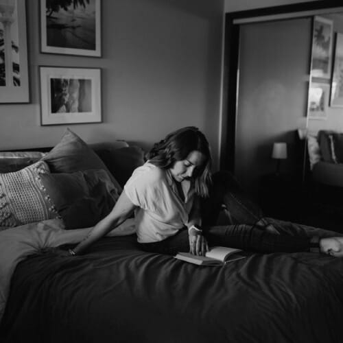 Coach Jen reading and taking notes in a journal, moment of personal reflection